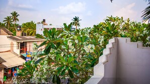 A view of a residential area with a white building, palm trees, and a signboard. - Located in Hikkaduwa, a 2-minute walk from town and supermarket hikkaduwa beach (Hikkaduwa)