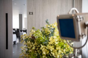 Un interior moderno con un mostrador de recepción, una planta y un cartel con el número 101.