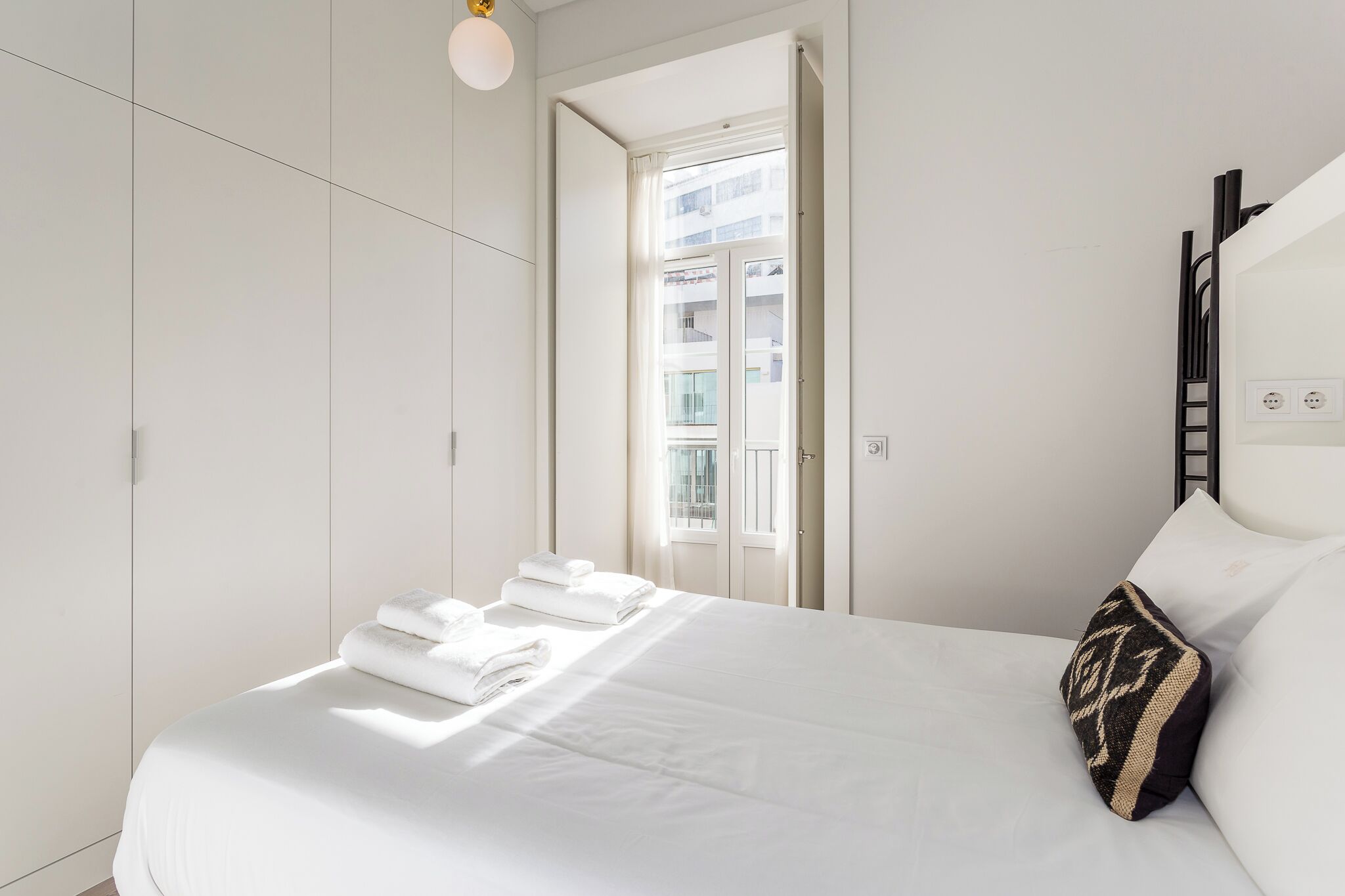 Une chambre d’hôtel avec un lit, une fenêtre et une armoire.