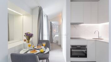 Apartamento superior, 1 quarto | Área de estar | TV