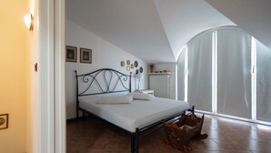 Une chambre à coucher avec un lit, un radiateur, une fenêtre avec des rideaux et une porte.