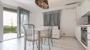 A modern kitchen with white cabinets, a built-in oven, and a stainless steel sink. - Villa Marina (Comacchio)