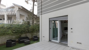 A modern patio with a sliding glass door leading to a kitchen area. - Villa Marina (Comacchio)