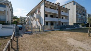 A multi-story residential building with balconies, a gated entrance, and a grassy courtyard. - Residence Smith 2 Piano Laterale E 3C (Comacchio)
