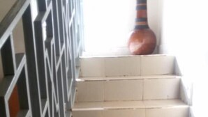 Un escalier avec des marches de couleur beige et une rampe en métal noir.
