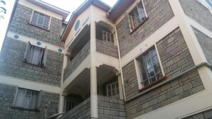 Un immeuble à plusieurs étages, doté d’une façade en briques, de nombreux balcons et de fenêtres.