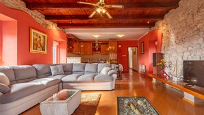 A modern living room with a sectional sofa, a glass coffee table, and a fireplace. - Villa Stocco ZadarVillas (Ugljan)