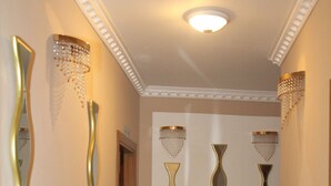 A hallway with decorative wall mirrors and a tiled floor.