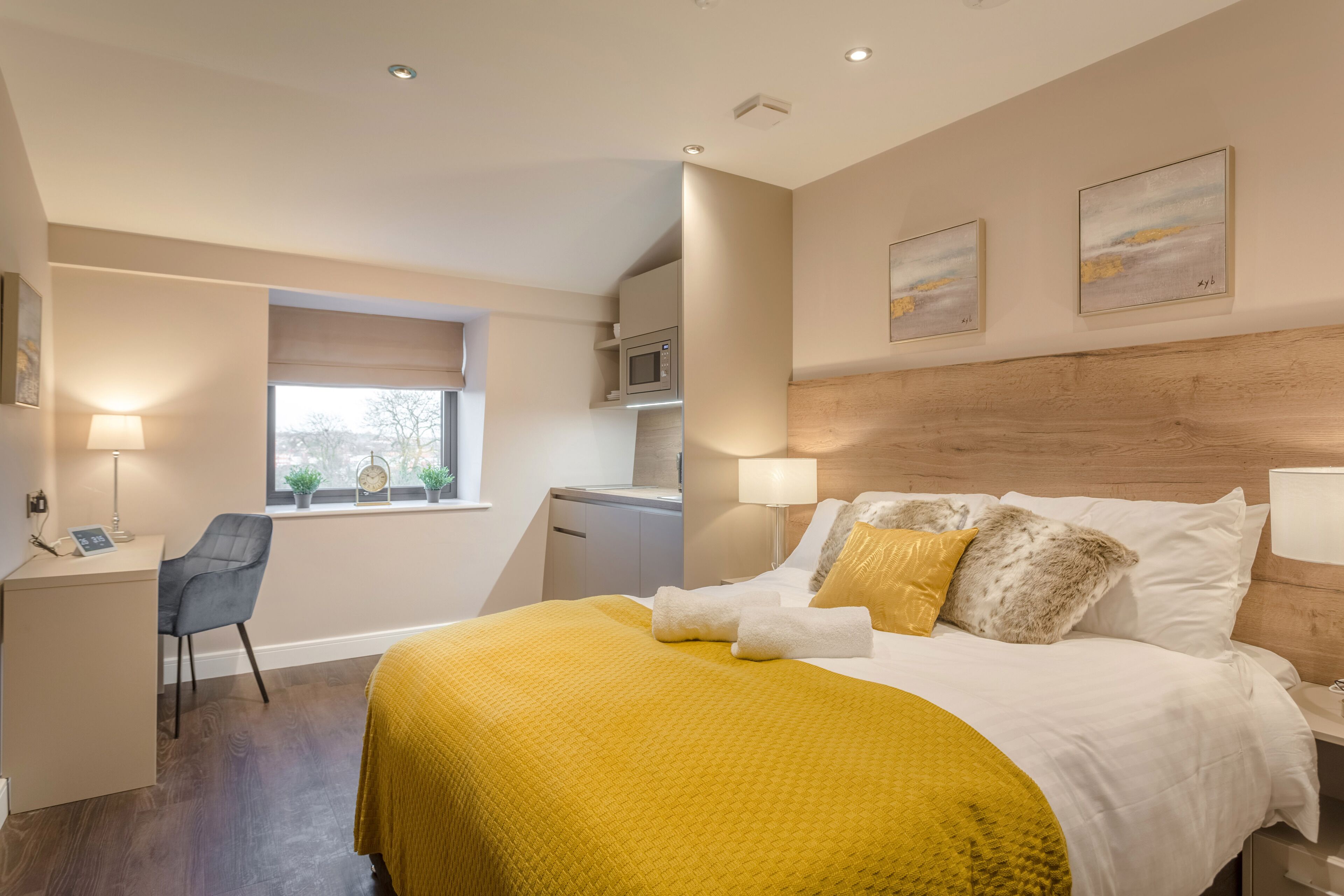 Una habitación de hotel moderna con cama, escritorio y kitchenette.