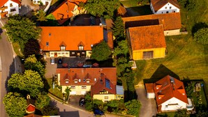 Eine Vogelperspektive auf ein Wohngebiet mit Häusern, Straßen und Grünflächen.