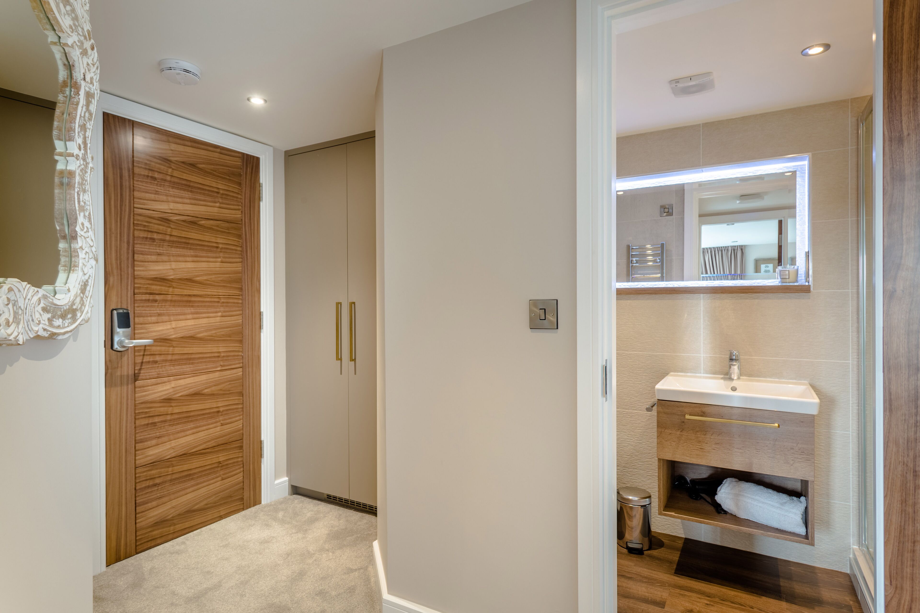 A modern bathroom with a vanity, mirror, and towel storage.