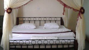 A bed with a canopy and a metal headboard. - Greenview Guest House (Kisumu)