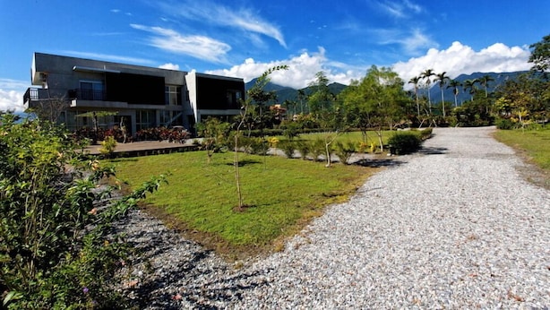A modern building with a gravel driveway and a well-maintained lawn. - Maple Farm (Guangfu)