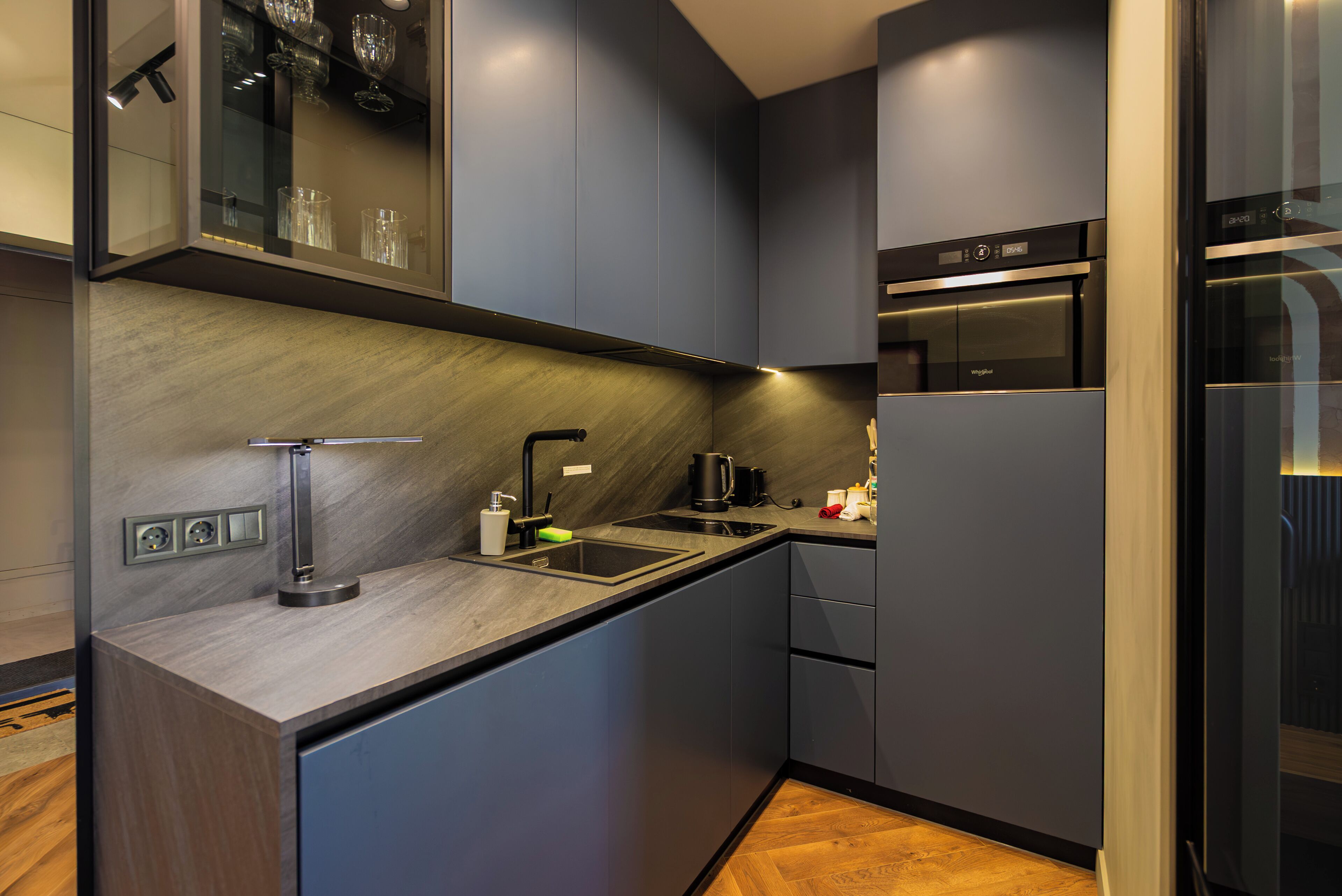 A modern kitchen with a built-in oven, a sink, and a countertop.