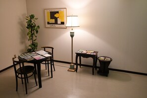 A room with a table displaying brochures, a lamp, a small table with a book, and a potted plant. - Guest House Ichibangai Room 403 / Kitami Hokkaidō (Kitami)