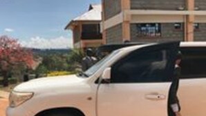 A white SUV parked in front of a building with a large window and a balcony. - The Horizon Resort (Kapenguria)