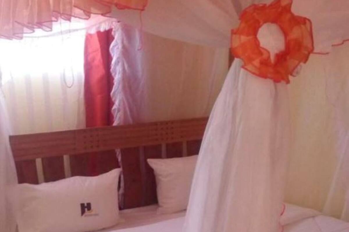 A bed with a canopy, pillows, and a wooden headboard.