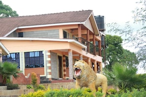 A two-story building with a balcony and a lion statue in front. - The Horizon Resort (Kapenguria)