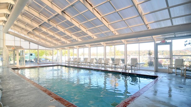 An indoor swimming pool with clear glass walls, a tiled floor, and a roof with a grid pattern. - FREE Dollywood Ticket • Whispering Pines 322 •  2bd/2ba • Mountain View • Pools (Pigeon Forge)