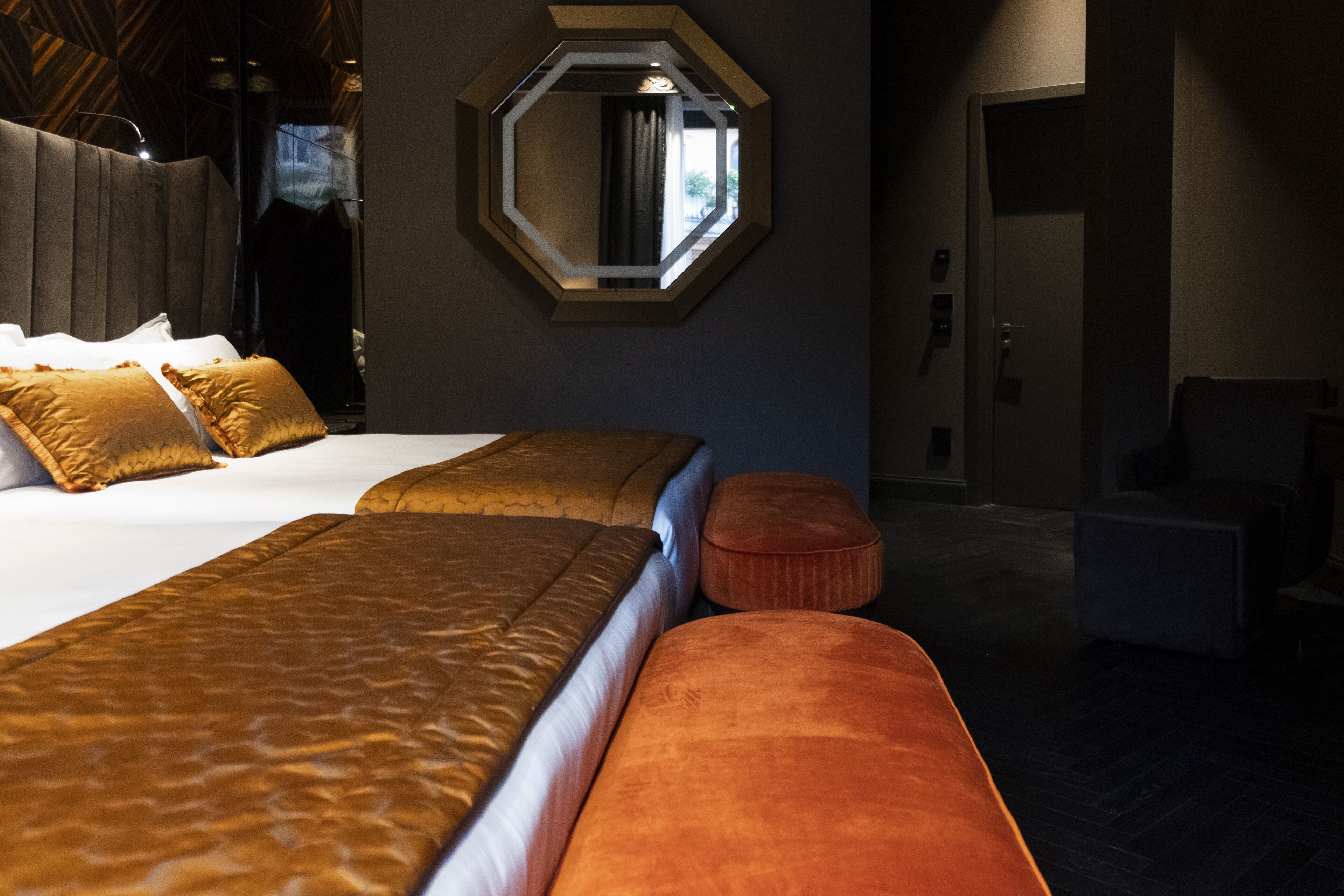 A hotel room with two beds, a large mirror, and a view of the outside.