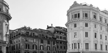 Fotografia in bianco e nero di un edificio storico con architettura classica, caratterizzato da numerosi balconi e dettagli decorativi.