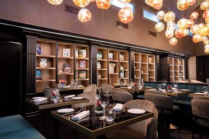 Un ristorante con diversi tavoli, sedie e un assortimento di libri e oggetti decorativi sugli scaffali.