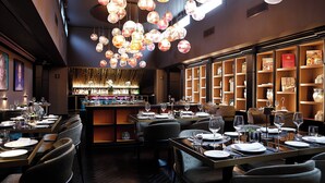 A restaurant interior with multiple dining tables, chairs, and a bar area. - U-Visionary Roma Hotel (Rome)