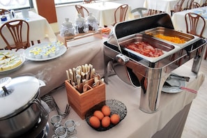 A buffet setup with various food items and utensils. - Hotel Igea Spiaggia (Bellaria-Igea Marina)
