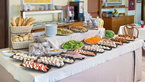 A buffet table with various food items, including bread, salads, and meats. - Hotel Igea Spiaggia (Bellaria-Igea Marina)