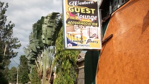 Señal para el alojamiento Western Guest Lounge, con número de contacto.