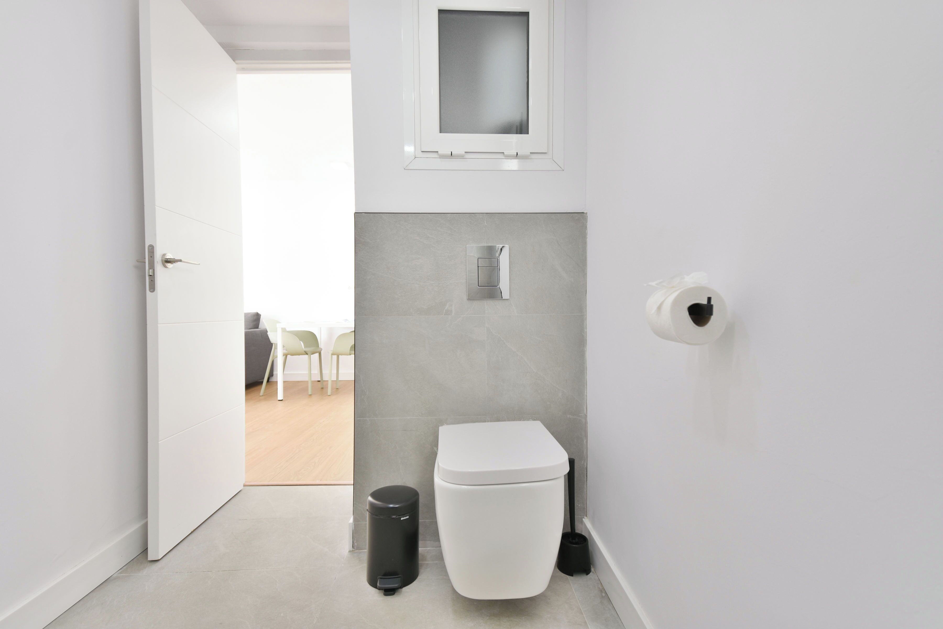 Un baño moderno con inodoro, bidé y cubo de basura.