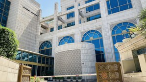 A modern building with a central courtyard, large windows, and decorative arches. - Seven Seas Hotel (New Delhi)