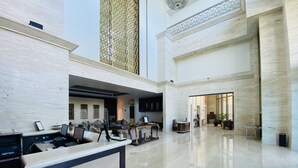 A spacious lobby with a reception desk, seating area, and a large open space. - Seven Seas Hotel (New Delhi)