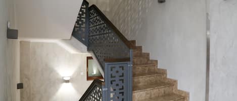 Una escalera con barandilla de madera y una ornamentada baranda azul.