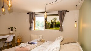 A bedroom with a bed, a desk, and a window with curtains. - Paradis (Cornier)