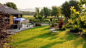 A well-maintained garden with a patio area, outdoor seating, and a view of the surrounding landscape. - Paradis (Cornier)
