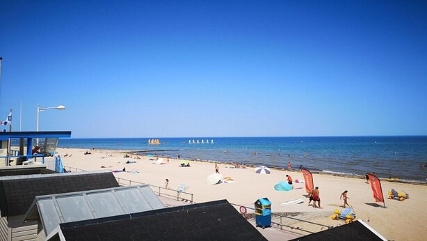 A beach with a lifeguard tower, umbrellas, and beachgoers. - 100 m from the beach in a pretty family seaside resort (Luc-sur-Mer)