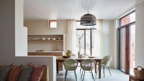 Une cuisine moderne avec des meubles en bois, un coin repas avec une table et des chaises, et un espace salon confortable avec un canapé.