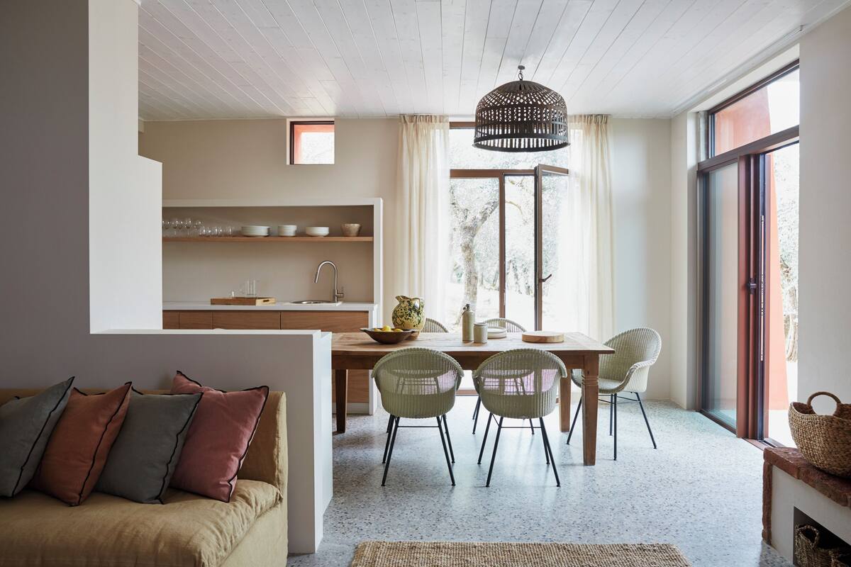 Een moderne keuken met houten kastjes, een eethoek met een tafel en stoelen, en een gezellige zithoek met een bank.
