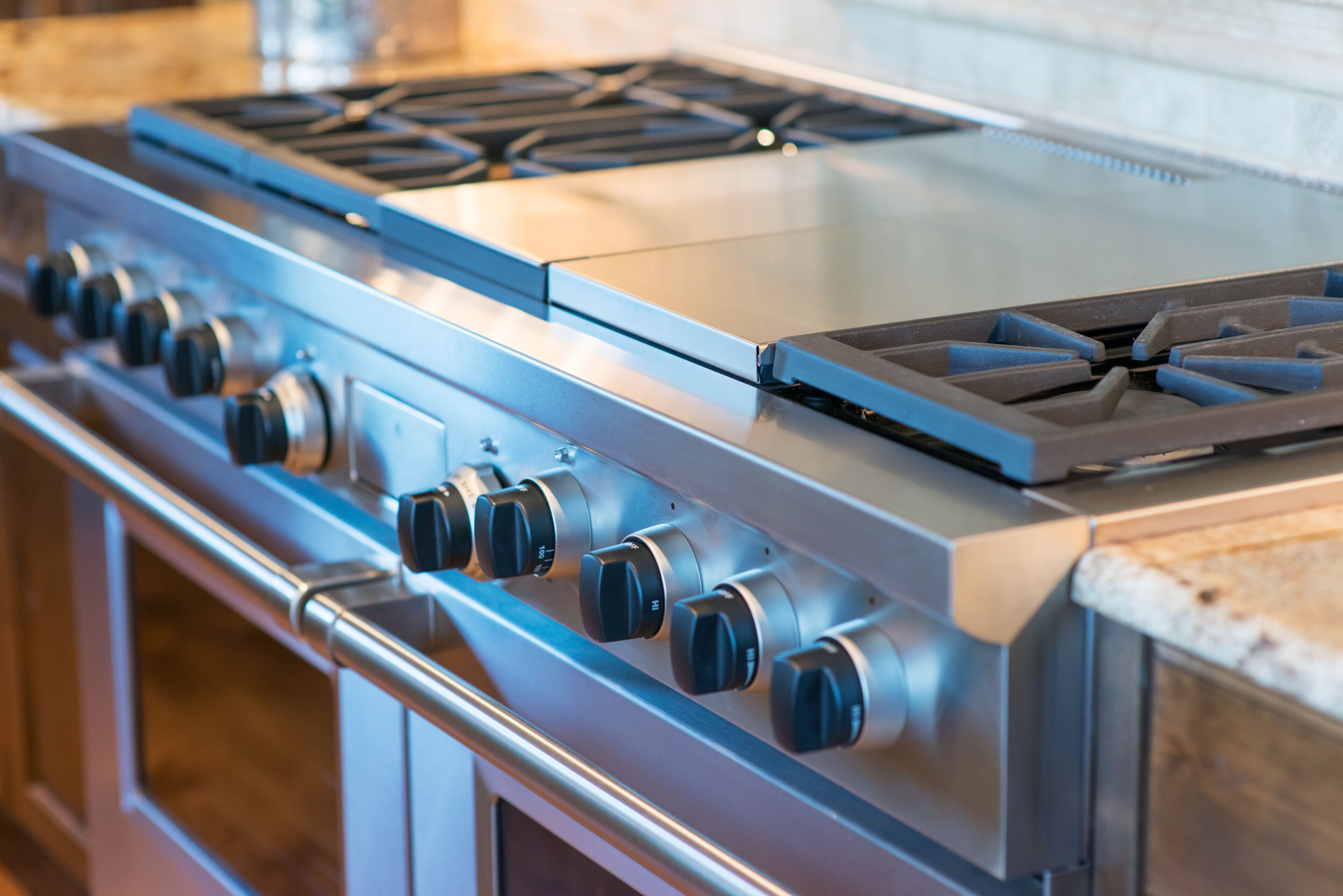 Una estufa de acero inoxidable con múltiples quemadores y perillas.