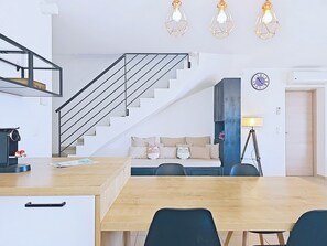 Une cuisine moderne dotée d’un plan de travail en bois, d’une cuisinière encastrée et d’une machine à café.