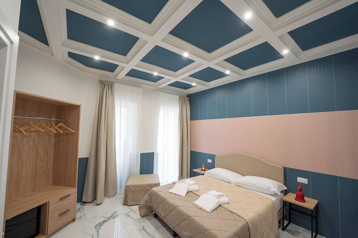 Ein Schlafzimmer mit Bett, einem Holzschrank, einem kleinen Tisch und einem Nachttisch.