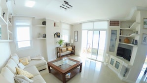 Un salón amplio con sofá, mesa de centro y estanterías.