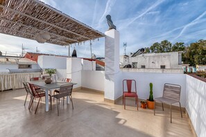 A rooftop terrace with a dining table and chairs, a grill, and potted plants. - Chuita - Holiday rental Pedregalejo (Málaga)