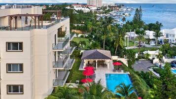 A hotel with multiple balconies, a pool area, and a view of the ocean and marina.