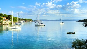 Un port de plaisance où sont amarrés plusieurs voiliers, l’eau est calme et le ciel est dégagé.
