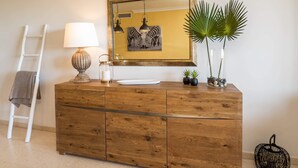 A wooden dresser with a mirror, a lamp, and two small potted plants. - SUPERB APARTMENT WITH SEA VIEW AND ELVIRIA GOLF COURSE (Marbella)