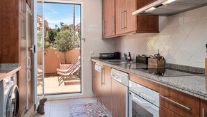 A modern kitchen with wooden cabinets, a dishwasher, and a built-in oven. - SUPERB APARTMENT WITH SEA VIEW AND ELVIRIA GOLF COURSE (Marbella)