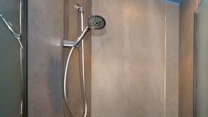 A modern shower with a handheld showerhead and a wall-mounted control. - Ottaviano Smart Rooms (Rome)
