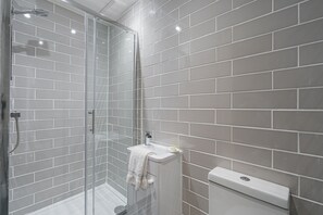 A modern bathroom with a glass-enclosed shower, a white sink, and a toilet. - Spacious 3BR New Town Apartment (Edinburgh)